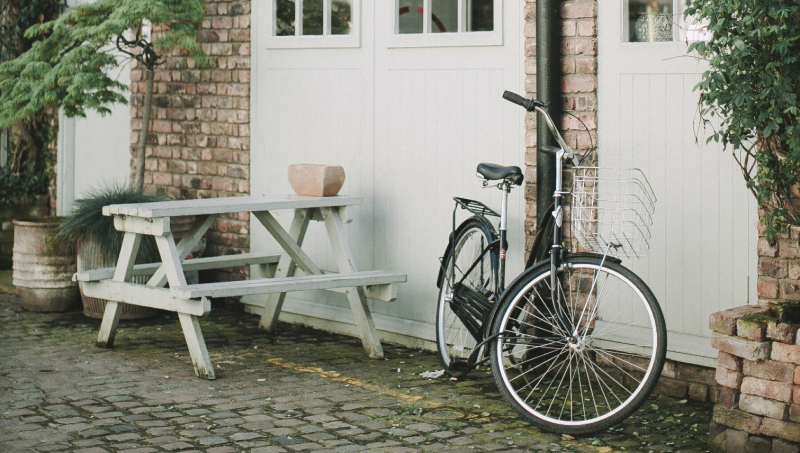 black-bicycle-parked-beside-white-wooden-chair-3639542